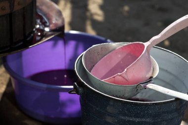 Şarap üreticisi varillere taşınmak için üzüm suyu döker..