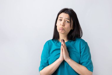 Çaresiz yüzlü güzel bir kız, yardım istiyor, avuç içlerini birbirine bastırıyor..