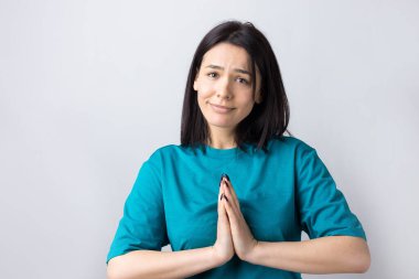 Çaresiz yüzlü güzel bir kız, yardım istiyor, avuç içlerini birbirine bastırıyor..