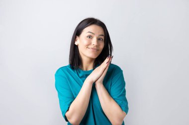 Çaresiz yüzlü güzel bir kız, yardım istiyor, avuç içlerini birbirine bastırıyor..