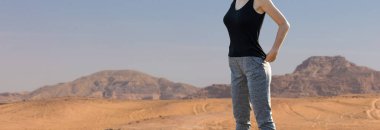 Zayıf bir atletik kız sabahın erken saatlerinde dağın arka planında dersler arasında mola verir.