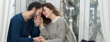 Pencereden dışarı bakan romantik bir çift. Evde karantina.