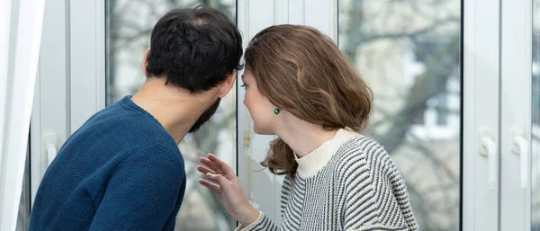 Pencereden dışarı bakan romantik bir çift. Evde karantina.