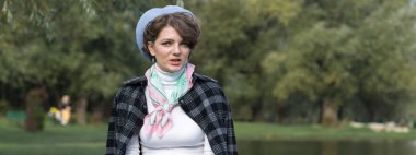 Parktaki genç kadın cep telefonuyla konuşuyor. Fransız tarzında şirin bir kız portresi..