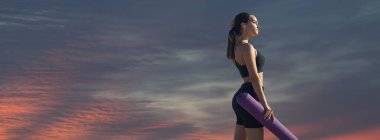 Tozlu, spor ayakkabılı ve üstü açık bir kız antrenman minderiyle egzersiz aralarında dinleniyor. Güzel atmosferik dramatik bulutlar.