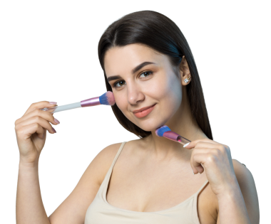 Açık renk bluzlu, beyaz arka planda yüz makyajı yapan genç bir kızın yakın çekimi. Güzel bir kadın yüzüne bir makyaj fırçası tutar ve gülümser..