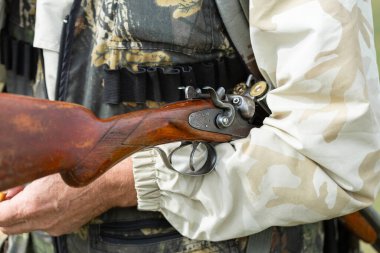 Bir avcının eline silahla yakın çekim. Silahlı bir avcının orta boy fotoğrafı..