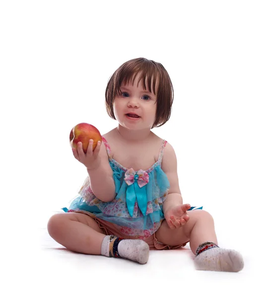Bebé niña en un vestido colorido jugando con manzana roja —  Fotos de Stock
