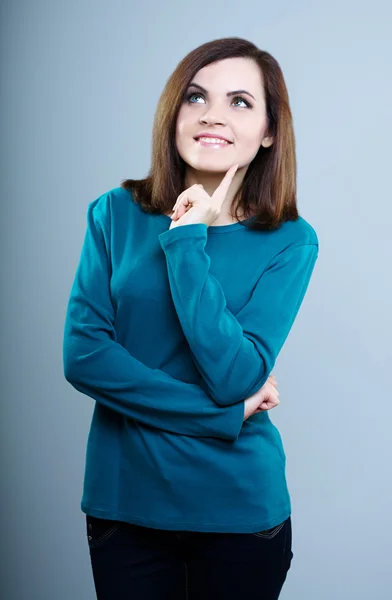 Nachdenkliches Mädchen in blauem T-Shirt, das vor grauem Hintergrund aufblickt — Stockfoto