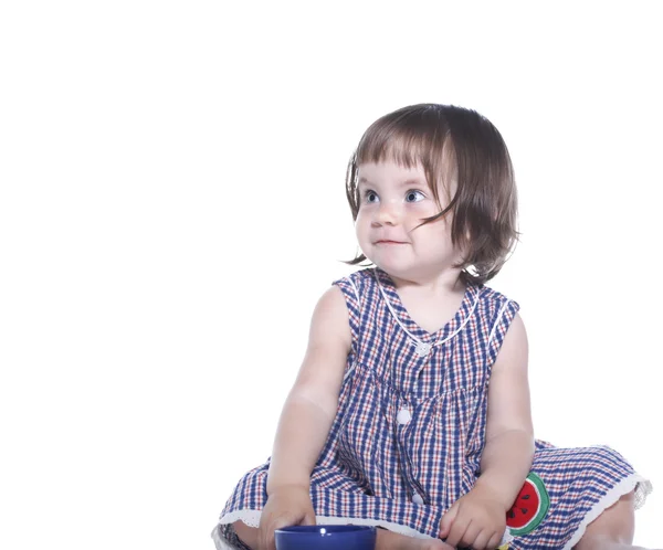 Bambina con un vestito a scacchi che tiene una tazza — Foto Stock