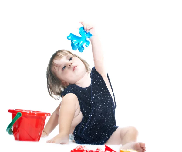 A menina de vestido azul. Ele está brincando com um balde . — Fotografia de Stock