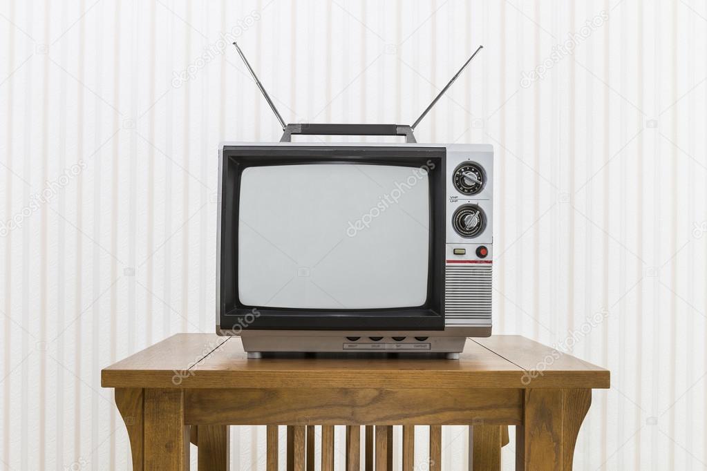 Old Portable Television with Antenna on Wood Table 