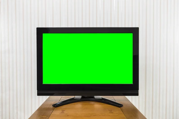 Televisión moderna en mesa de madera con pantalla de croma verde Imagen de archivo