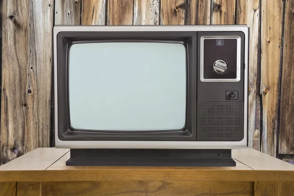 Alter Fernseher und Tisch mit rustikaler Holzwand — Stockfoto