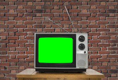Eski televizyon Chroma anahtar yeşil ekran ve tuğla duvar