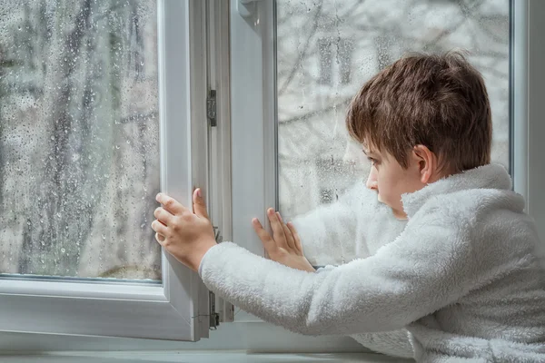 portrait of a pensive young man looking away through a wet wind