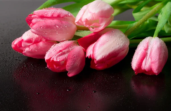 Frühlingsblume rosa Tulpen Strauß auf schwarzem Hintergrund. — Stockfoto