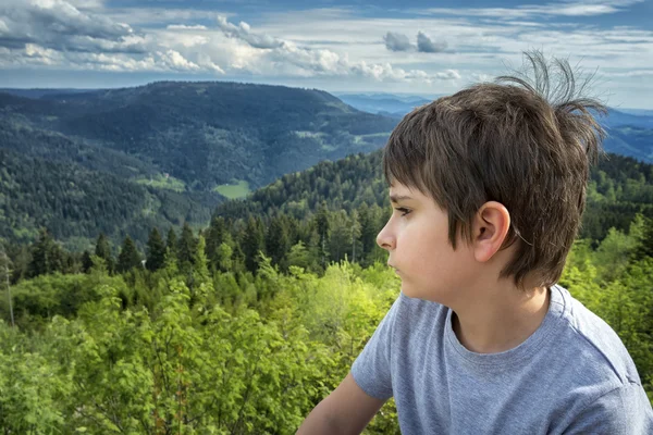 Retrato de un colegial sobre un fondo de paisaje de montaña — Foto de Stock