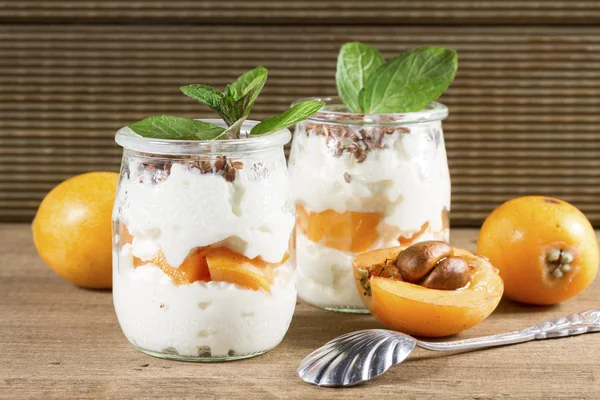 Färsk yoghurt med mispel på rustika bakgrund — Stockfoto