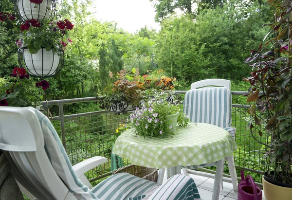 Letní terasa nebo balkón s malými stůl, židli a květiny — Stock fotografie