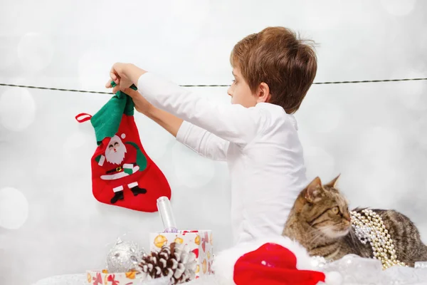 Garçon accroche des chaussettes pour le Père Noël . — Photo