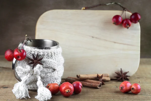 Panneau blanc avec une tasse en couverture tricotée — Photo