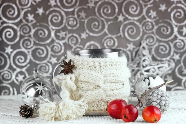 Чашка в вязаной обложке с рождественскими украшениями . — стоковое фото