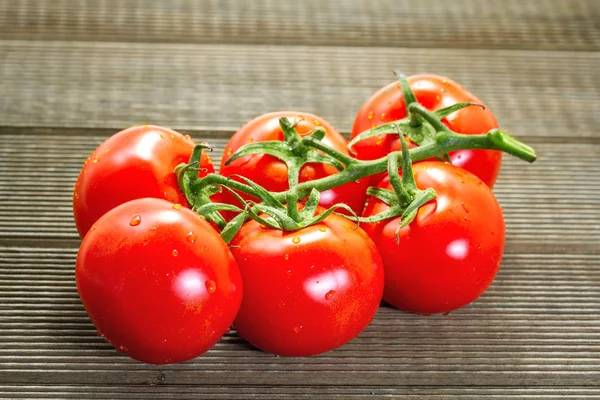 Tomates frescos em uma mesa de madeira — Fotografia de Stock