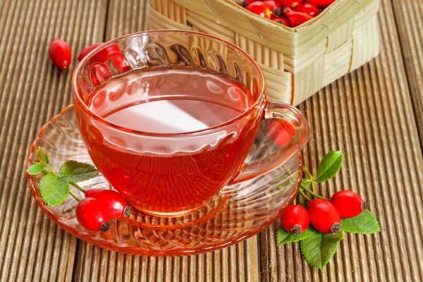 Чай из шиповника со свежими ягодами на деревянном фоне — стоковое фото