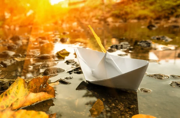 Barco de papel en un agua y hojas de caída. Imagen tonificada . —  Fotos de Stock