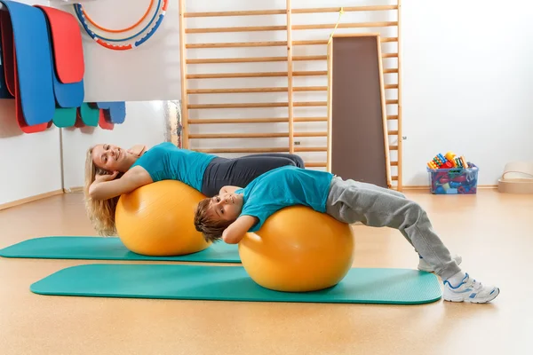 Happy, sports family, mother and son perform gymnastic exercises