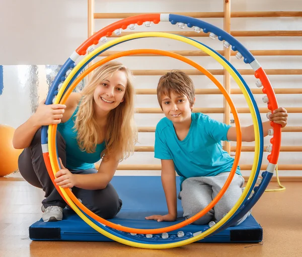 Felice, famiglia sportiva, madre e figlio guardando attraverso hula hoops — Foto Stock