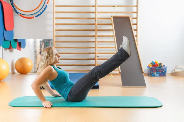 Giovane donna che fa esercizi sportivi in palestra . — Foto Stock