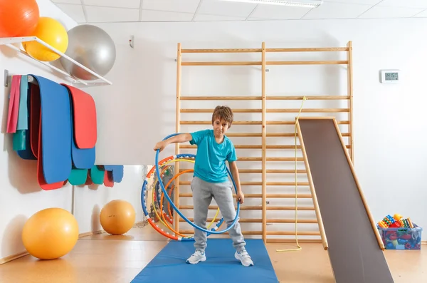 Genç çocuk hula hoop egzersiziyle spor salonunda gerçekleştirir.. — Stok fotoğraf