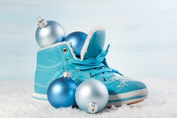Блакитне взуття з різдвяними прикрасами на снігу. Різдво назад — стокове фото
