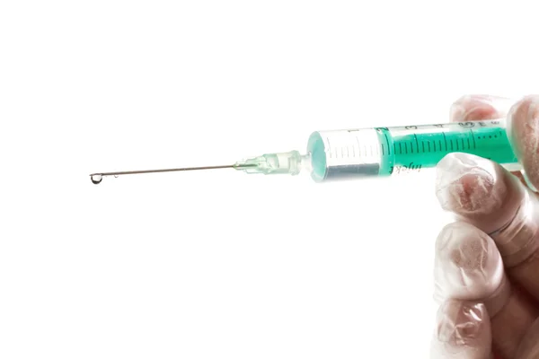 Hand in een handschoen bedrijf syringe geïsoleerd op wit — Stockfoto