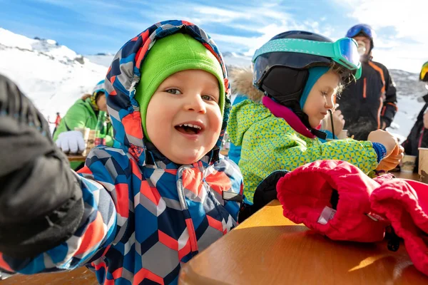 Bonito adorável feliz engraçado caucasiano pequeno criança menino desfrutar de ter família diversão e fazer selfie com telefone no alpino montanha europeu ski resort no ensolarado dia de inverno. Brincalhão sorrindo retrato criança — Fotografia de Stock