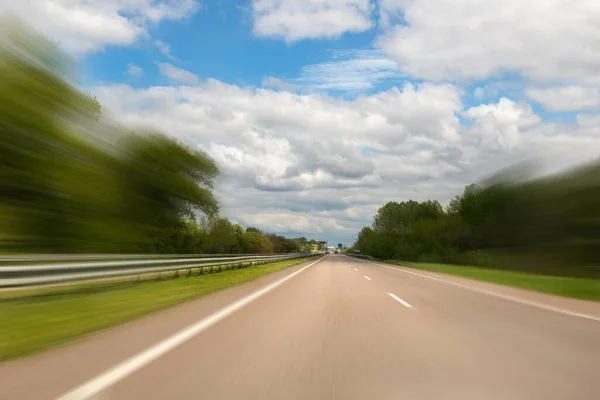 Автомобильная дорога Emtpy suburaban highway с движением размыла быструю скорость движения на фоне голубого неба. Перспективный ландшафт автомагистрали — стоковое фото