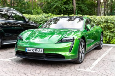 Kyiv, Ukrayna - 6 Eylül 2020: Yeni elektrikli sıfır emisyon spor otomobili Porsche Taycan turbo Mamba yeşil metalik rengi sonbahar günü şehir sokaklarında park halinde.