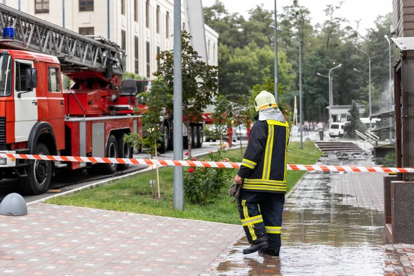 İtfaiyeciler yangın bandının arkasında duran üniformasız itfaiyeciler ve merdivenli itfaiye araçları şehir merkezindeki yüksek kulede ya da ofis binasında kaza yaptı. Felakette acil yardım