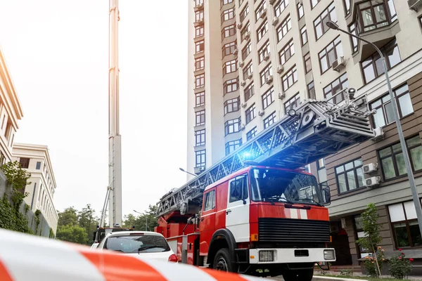 Πολλά πυροσβεστικά οχήματα με σκάλα και εξοπλισμό ασφαλείας κατά λάθος σε highrise πύργο οικιστικό διαμέρισμα ή κτίριο γραφείων στο κέντρο της πόλης. Επείγουσα διάσωση σε περίπτωση καταστροφής — Φωτογραφία Αρχείου