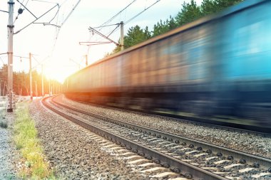 Hareket, ağır kargo, paslı tren vagonlarının gün batımında ya da gün doğumunda demiryolunda hareket etmesini engelledi. Endüstriyel malzeme taşımacılığı ve mal teslimatı kavramı. Eski paslı vagonlar demiryolu ile hareket ediyor.