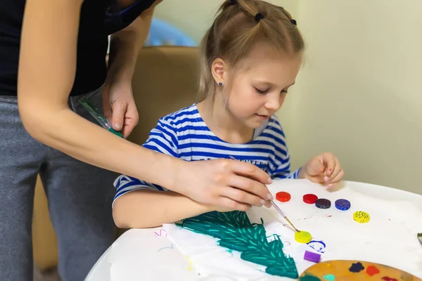 Madre e bambino insieme rendendo il nuovo anno Natale legno naturale vintage abete giocattolo pittura colore verde. Ragazzo felice facendo fatto a mano concetto di decorazione d'arte di Natale. Bambini fai da te hobby a casa — Foto Stock