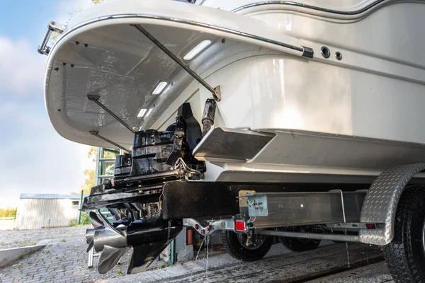 Big luxury cabin motorboat cruiser yacht engine at trailer ramp from storage boat hangar garage. Ship service, cleaning, repair or maintenance concept. Luxury fishing leisure recreation lifestyle.