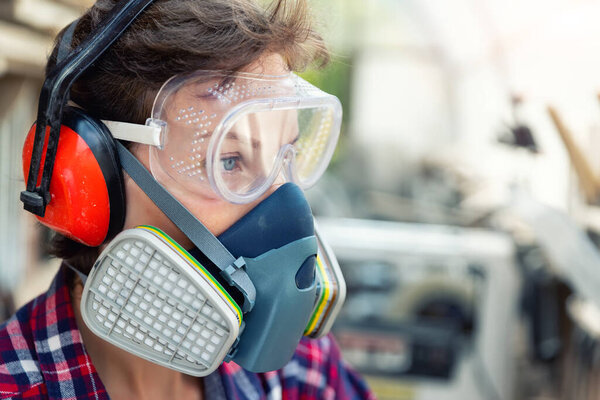 Young adult caucasian mid aged professional female carpenter grinding raw wood with orbital sander tool in carpentry diy workshop. Feminine women equality concept. Women do male hobby at workbench