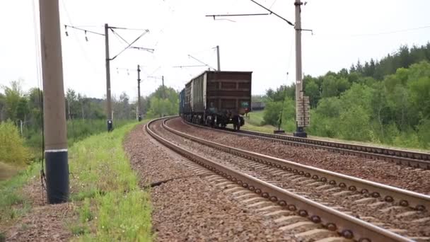 Heavy cargo freight rusty rear tail end of train wagons moving on railway on day time. Industrial materials transportation and goods delivery concept. Old rusty wagons moving by rail — Stock Video