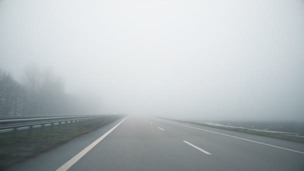 Οδηγός POV άδειο γκρι ομιχλώδες βροχερό αυτοκινητόδρομο intercity δρόμο με χαμηλή κακή ορατότητα στο κρύο άνοιξη ar φθινόπωρο πρωί. Εποχιακή κακή βροχερό καιρικό ατύχημα προειδοποίηση κινδύνου — Αρχείο Βίντεο