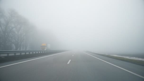 Οδηγός POV άδειο γκρι ομιχλώδες βροχερό αυτοκινητόδρομο intercity δρόμο με χαμηλή κακή ορατότητα στο κρύο άνοιξη ar φθινόπωρο πρωί. Εποχιακή κακή βροχερό καιρικό ατύχημα προειδοποίηση κινδύνου — Αρχείο Βίντεο