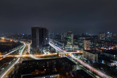 Kiev 'in gece trafiği kavşağının çatısında hava panoramik dronu var. Otoyol kenti akşam arabasının ışık yollarında. Manzaralı şehir silueti. Ukrayna başkentinin yoğun şehir hayatı
