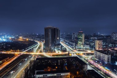 Kiev 'in gece trafiği kavşağının çatısında hava panoramik dronu var. Otoyol kenti akşam arabasının ışık yollarında. Manzaralı şehir silueti. Ukrayna başkentinin yoğun şehir hayatı